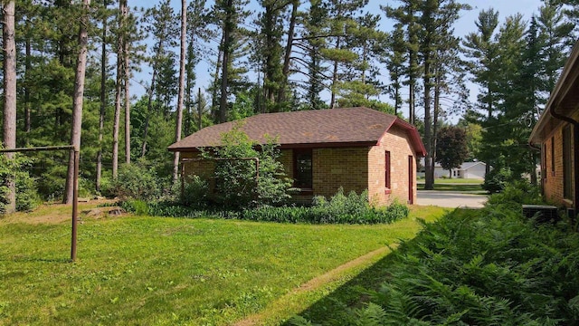 452 Woodland Dr, Wisconsin Rapids, WI 54494 - view of side of property with brick siding and a lawn