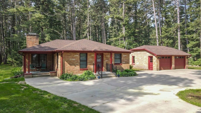 452 Woodland Dr, Wisconsin Rapids, WI 54494 - view of front of house with a chimney, an outdoor structure, brick siding, and a forest view