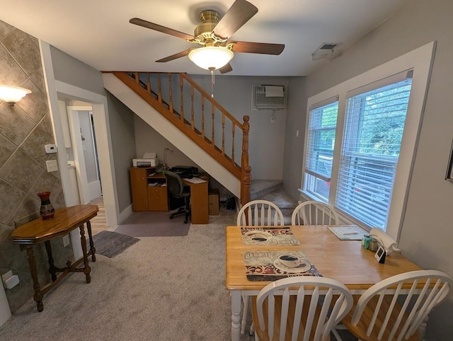 219 Guenther St, Oshkosh, WI 54902 - carpeted dining space featuring a wall mounted AC, stairs, a ceiling fan, and a desk