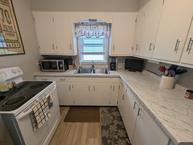 219 Guenther St, Oshkosh, WI 54902 - kitchen with white electric stove, stainless steel microwave, light countertops, and white cabinetry