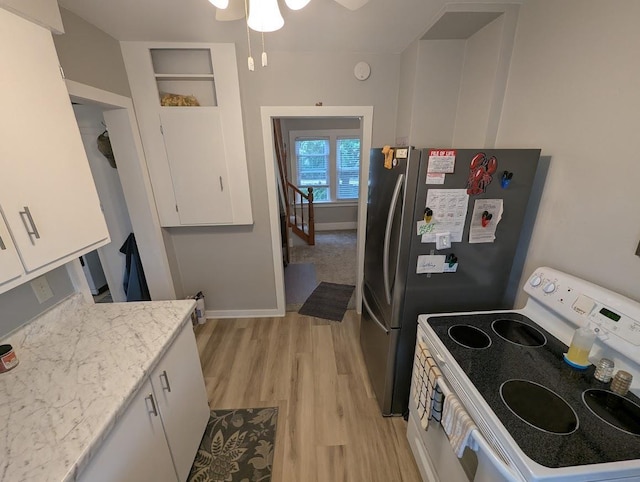 219 Guenther St, Oshkosh, WI 54902 - kitchen featuring white electric stove, white cabinetry, light wood-style flooring, a ceiling fan, and light stone countertops