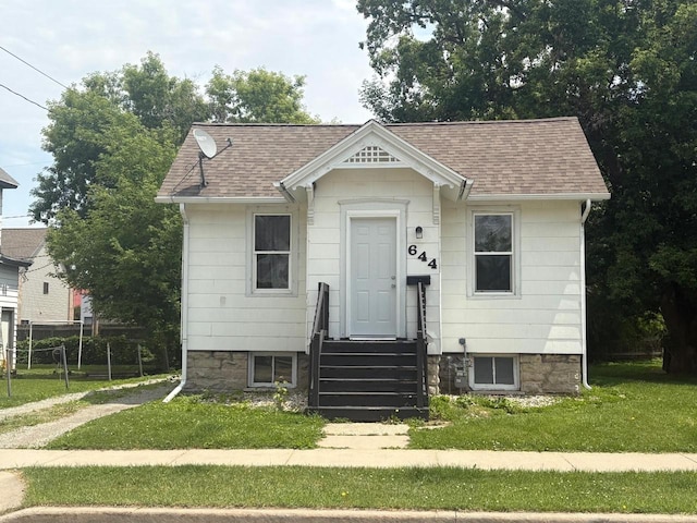 644 Central St, Oshkosh, WI 54901 - view of front of property with a shingled roof and a front yard
