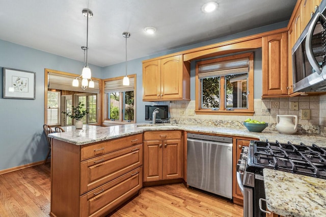 6265 N Bay Ridge Ave, Whitefish Bay, WI 53217 - kitchen featuring stainless steel appliances, a peninsula, light wood-type flooring, and backsplash