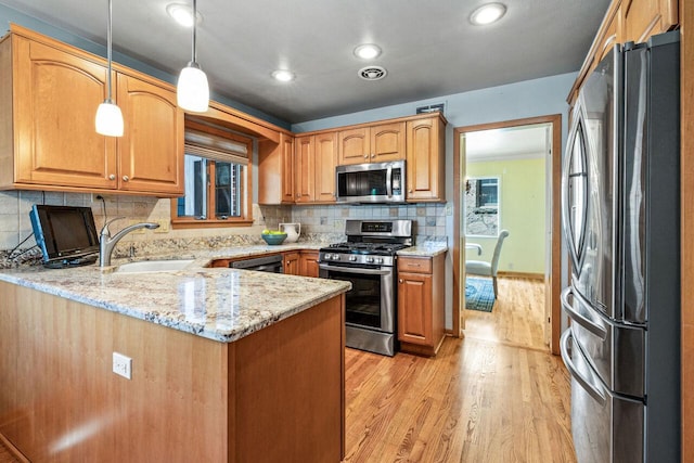 6265 N Bay Ridge Ave, Whitefish Bay, WI 53217 - kitchen with appliances with stainless steel finishes, light wood-type flooring, a peninsula, light stone counters, and tasteful backsplash