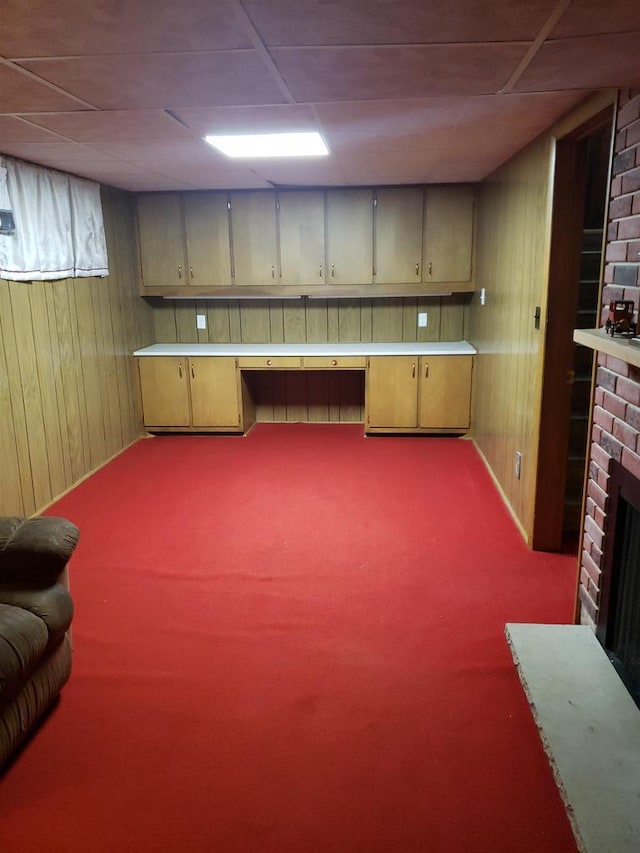 809 N 5th Ave, Wausau, WI 54401 - basement with wood walls, carpet floors, a brick fireplace, and built in desk