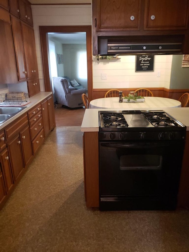 809 N 5th Ave, Wausau, WI 54401 - kitchen featuring black gas stove, ventilation hood, light countertops, and brown cabinetry