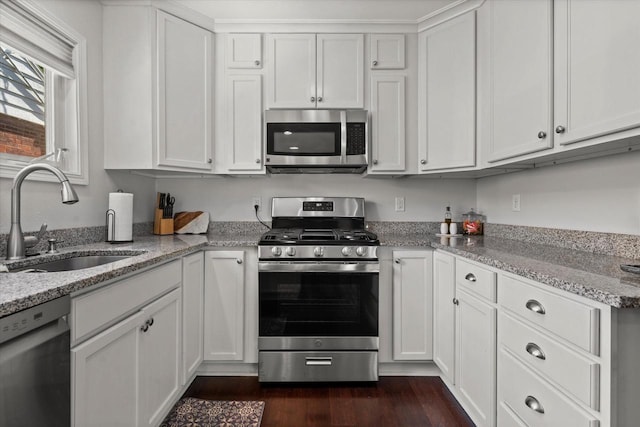 150 E Fairmount Ave, Whitefish Bay, WI 53217 - kitchen with stainless steel appliances, white cabinets, light stone counters, and dark wood-style flooring