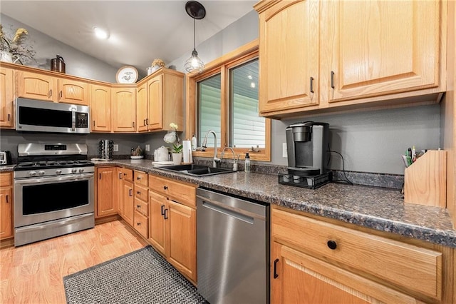 10525 Voight Rd, Fall Creek, WI 54742 - kitchen featuring appliances with stainless steel finishes, dark countertops, vaulted ceiling, light wood finished floors, and pendant lighting