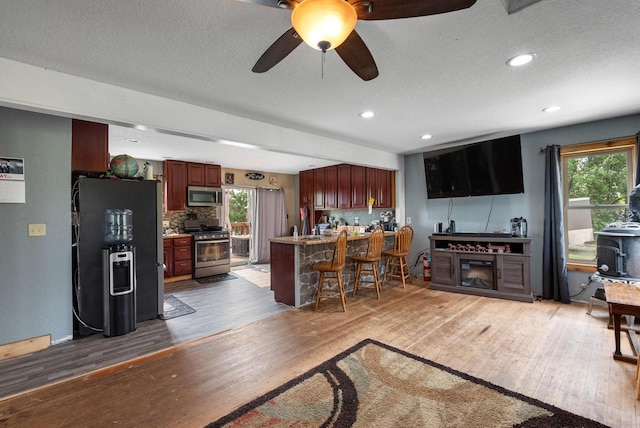 N7082 Airport Rd, Beaver Dam, WI 53916 - living room featuring light wood finished floors, healthy amount of natural light, a ceiling fan, a textured ceiling, and recessed lighting