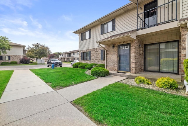 4008 81st St Unit B, Kenosha, WI 53142 - view of front facade featuring a balcony, a front lawn, and brick siding