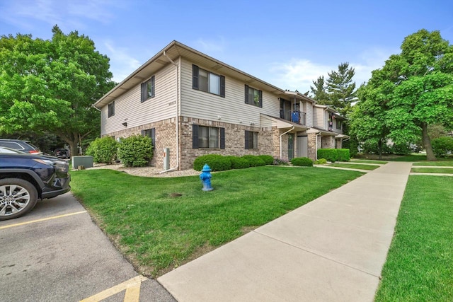 4008 81st St Unit B, Kenosha, WI 53142 - townhome / multi-family property featuring a front lawn, brick siding, and uncovered parking