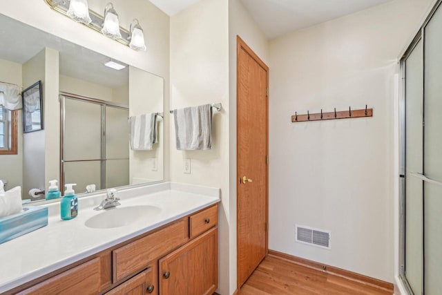 1910 Cedar St, Grafton, WI 53024 - bathroom featuring wood finished floors, a shower stall, and vanity
