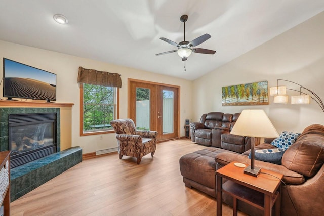 1910 Cedar St, Grafton, WI 53024 - living area featuring lofted ceiling, light wood-style floors, a tiled fireplace, a ceiling fan, and baseboard heating