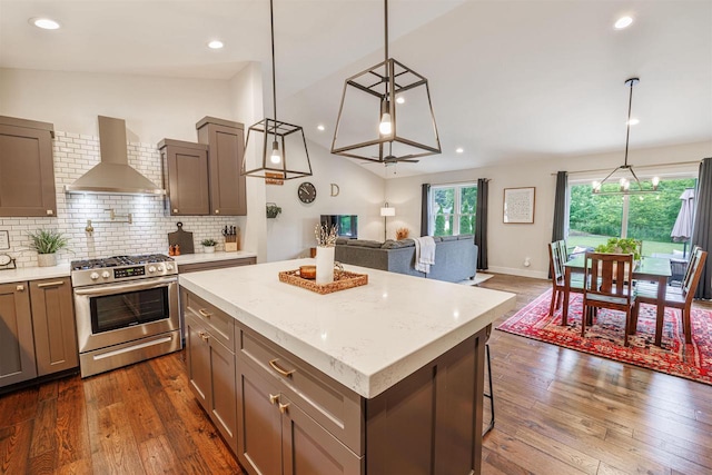3717 White Pine Dr, Janesville, WI 53545 - kitchen with gas stove, range hood, open floor plan, dark wood finished floors, and backsplash