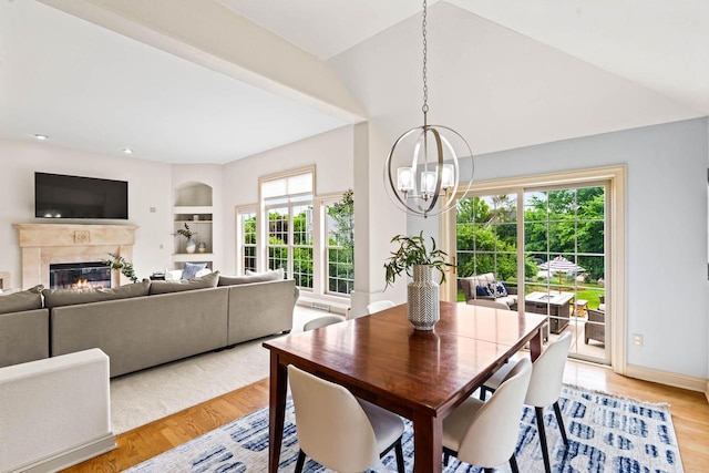N53W16527 Whitetail Run, Menomonee Falls, WI 53051 - dining room with a chandelier, light wood-type flooring, a glass covered fireplace, and built in shelves