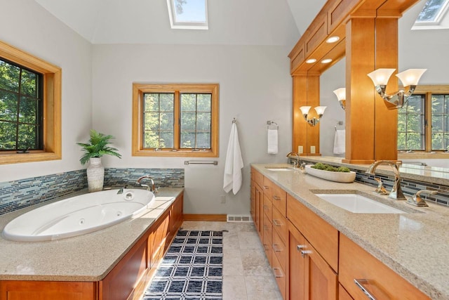 13835 Stonefield Ct, Elm Grove, WI 53122 - full bathroom with healthy amount of natural light, double vanity, a skylight, a whirlpool tub, and lofted ceiling