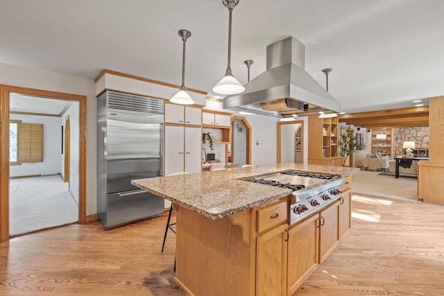 13835 Stonefield Ct, Elm Grove, WI 53122 - kitchen with appliances with stainless steel finishes, island exhaust hood, light wood finished floors, light stone counters, and a center island