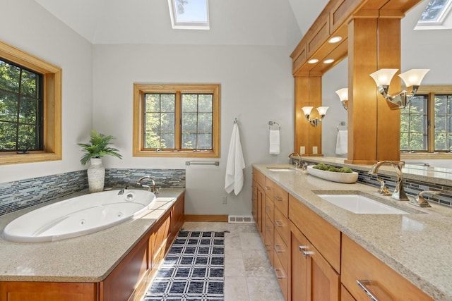 13835 Stonefield Ct, Elm Grove, WI 53122 - full bath featuring healthy amount of natural light, double vanity, a skylight, a whirlpool tub, and lofted ceiling