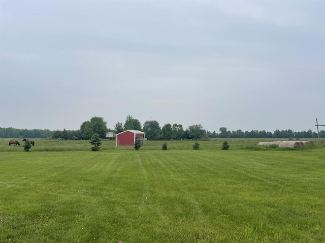 N3315 Brook Dr, Medford, WI 54451 - view of grassy yard featuring a rural view, an outdoor structure, a garage, and an outbuilding