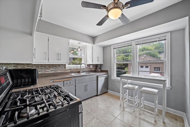 165 N 72nd St, Milwaukee, WI 53213 - kitchen featuring stainless steel dishwasher, gas range oven, backsplash, white cabinetry, and ceiling fan
