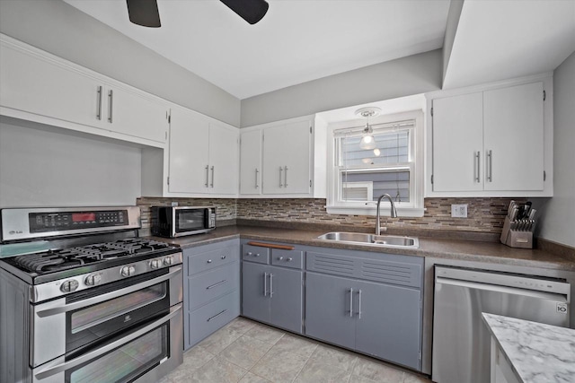 165 N 72nd St, Milwaukee, WI 53213 - kitchen with stainless steel appliances, backsplash, ceiling fan, and white cabinets