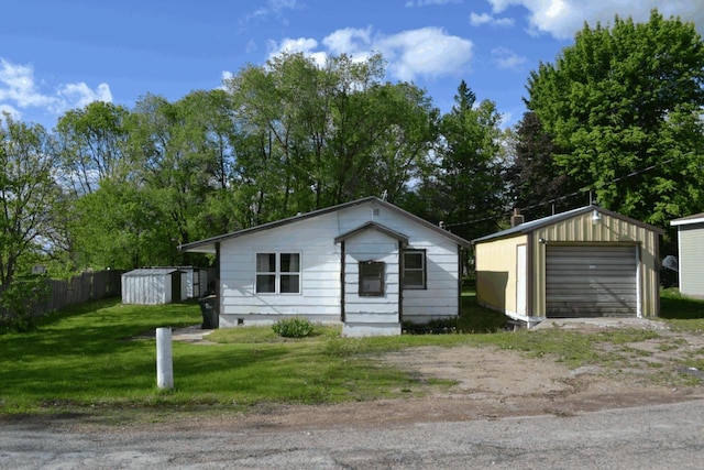 653 Grant St, Wonewoc, WI 53968 - view of front of home featuring dirt driveway, an outbuilding, and a detached garage