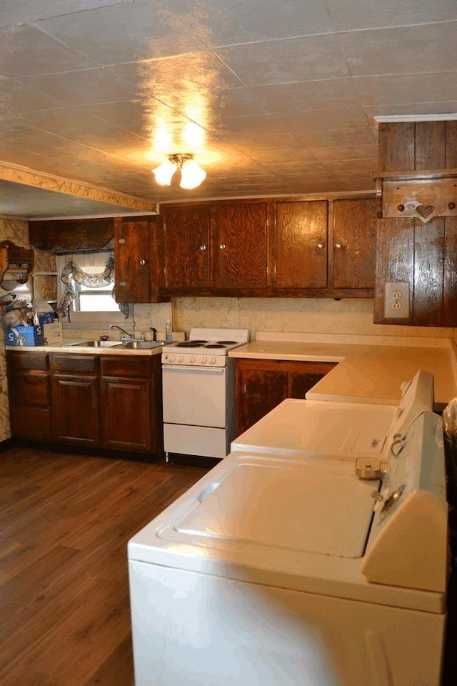 653 Grant St, Wonewoc, WI 53968 - kitchen featuring white electric stove, washing machine and dryer, dark wood-style floors, and light countertops