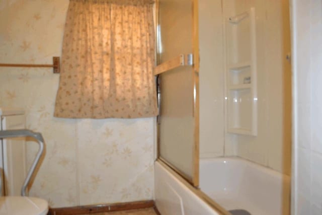 653 Grant St, Wonewoc, WI 53968 - bathroom featuring enclosed tub / shower combo and wallpapered walls