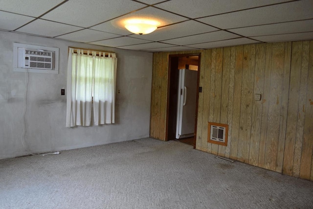 653 Grant St, Wonewoc, WI 53968 - unfurnished room featuring carpet, a drop ceiling, heating unit, a wall mounted AC, and wood walls