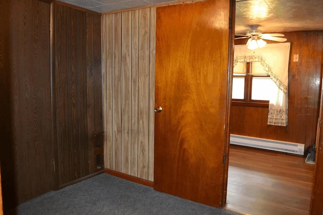 653 Grant St, Wonewoc, WI 53968 - unfurnished room featuring a baseboard heating unit, wood walls, and ceiling fan
