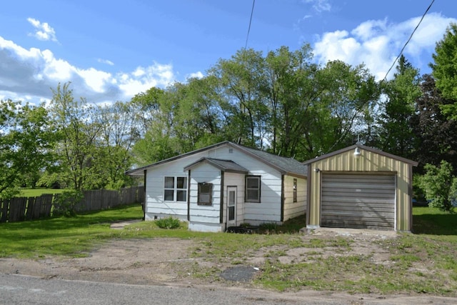 653 Grant St, Wonewoc, WI 53968 - view of front facade with an outbuilding, a detached garage, and driveway