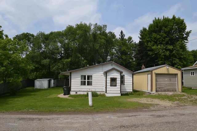 653 Grant St, Wonewoc, WI 53968 - view of front of home featuring driveway, an outbuilding, a garage, and view of scattered trees