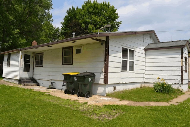 653 Grant St, Wonewoc, WI 53968 - back of property with entry steps, crawl space, and a lawn