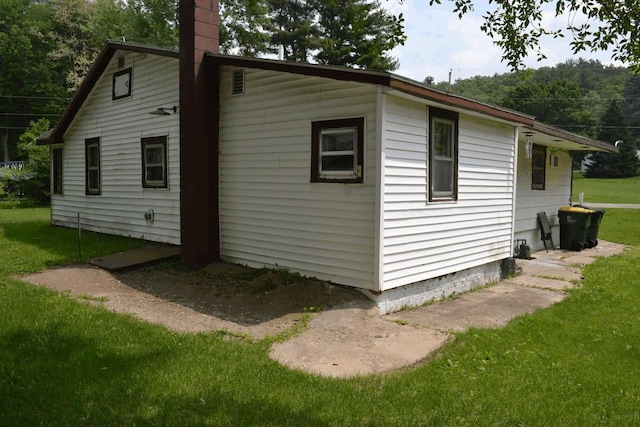 653 Grant St, Wonewoc, WI 53968 - view of side of property with a lawn and a chimney
