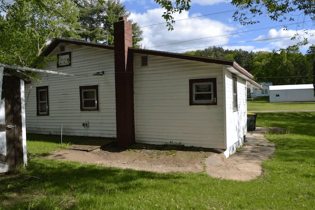 653 Grant St, Wonewoc, WI 53968 - view of side of home with a yard and a chimney