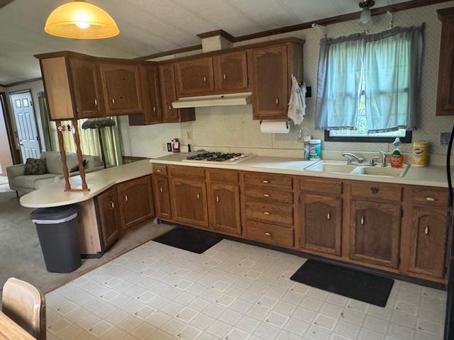 W211N11783 Hilltop Cir, Germantown, WI 53022 - kitchen with white gas stovetop, under cabinet range hood, ornamental molding, light countertops, and a peninsula