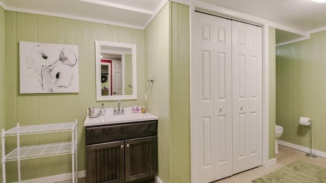 514 Fairfield Ct, Chippewa Falls, WI 54729 - bathroom featuring a closet, vanity, wood walls, and ornamental molding