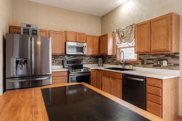 850 E Mckearn Ln, Beloit, WI 53511 - kitchen with stainless steel appliances, backsplash, light countertops, and brown cabinets