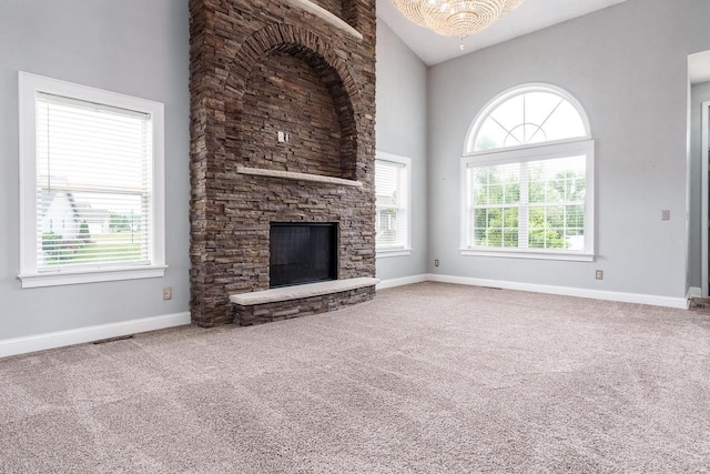 850 E Mckearn Ln, Beloit, WI 53511 - unfurnished living room featuring plenty of natural light, carpet floors, a fireplace, high vaulted ceiling, and a chandelier