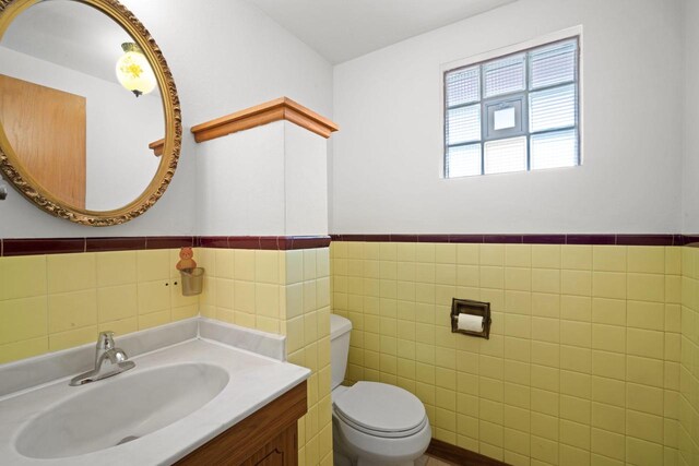 5110 W Cleveland Ave, Milwaukee, WI 53219 - half bathroom featuring tile walls, vanity, and a wainscoted wall