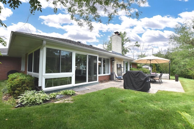 4729 James Ave, Wind Point, WI 53402 - rear view of house featuring brick siding, a patio, a chimney, a yard, and a sunroom