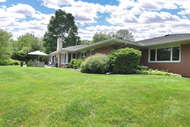 4729 James Ave, Wind Point, WI 53402 - view of side of home with a chimney, brick siding, and a lawn