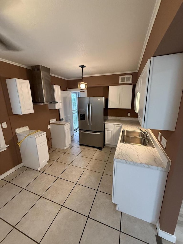 5411 N 37th St, Milwaukee, WI 53209 - kitchen with stainless steel fridge with ice dispenser, ornamental molding, white cabinets, light countertops, and wall chimney exhaust hood