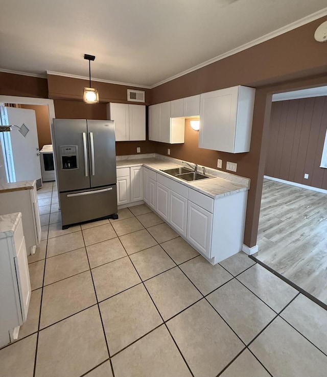 5411 N 37th St, Milwaukee, WI 53209 - kitchen featuring stainless steel refrigerator with ice dispenser, white cabinetry, light countertops, ornamental molding, and light tile patterned floors
