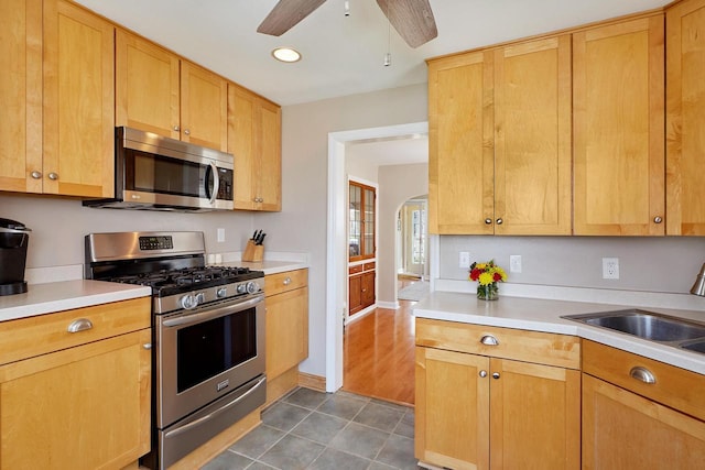 3057 N 90th St, Milwaukee, WI 53222 - kitchen with appliances with stainless steel finishes, ceiling fan, light countertops, dark tile patterned floors, and arched walkways