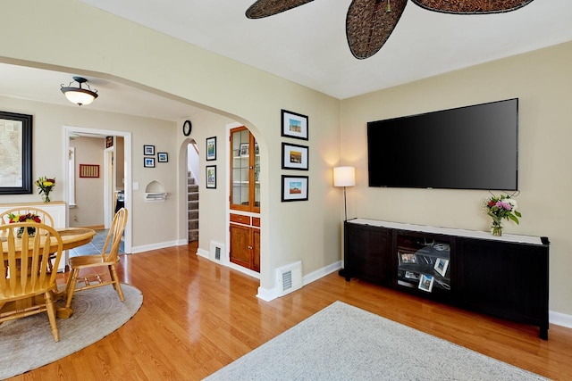 3057 N 90th St, Milwaukee, WI 53222 - living area with arched walkways, light wood finished floors, and ceiling fan