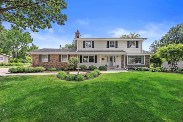 6500 S 121st St, Franklin, WI 53132 - traditional-style house with a chimney, a front yard, and brick siding