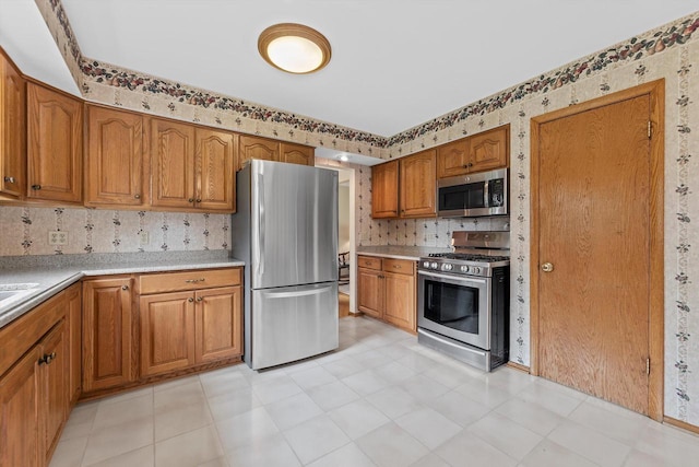 6500 S 121st St, Franklin, WI 53132 - kitchen with appliances with stainless steel finishes, brown cabinetry, light countertops, tasteful backsplash, and wallpapered walls