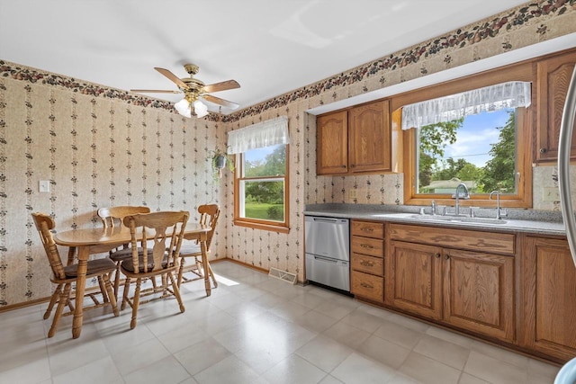 6500 S 121st St, Franklin, WI 53132 - kitchen with wallpapered walls, dishwasher, brown cabinetry, and a ceiling fan