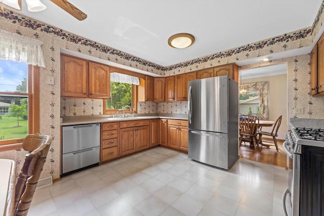 6500 S 121st St, Franklin, WI 53132 - kitchen with appliances with stainless steel finishes, light countertops, tasteful backsplash, wallpapered walls, and brown cabinets